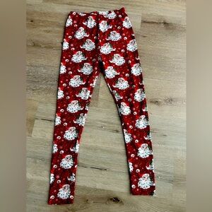 Buttery soft Christmas leggings they have Santa heads and mistletoe on them.